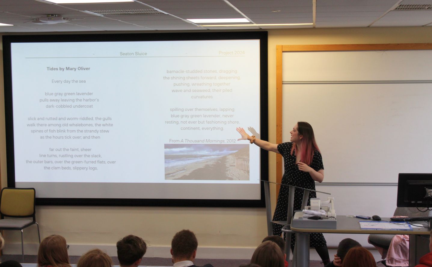A person pointing at text on a whiteboard